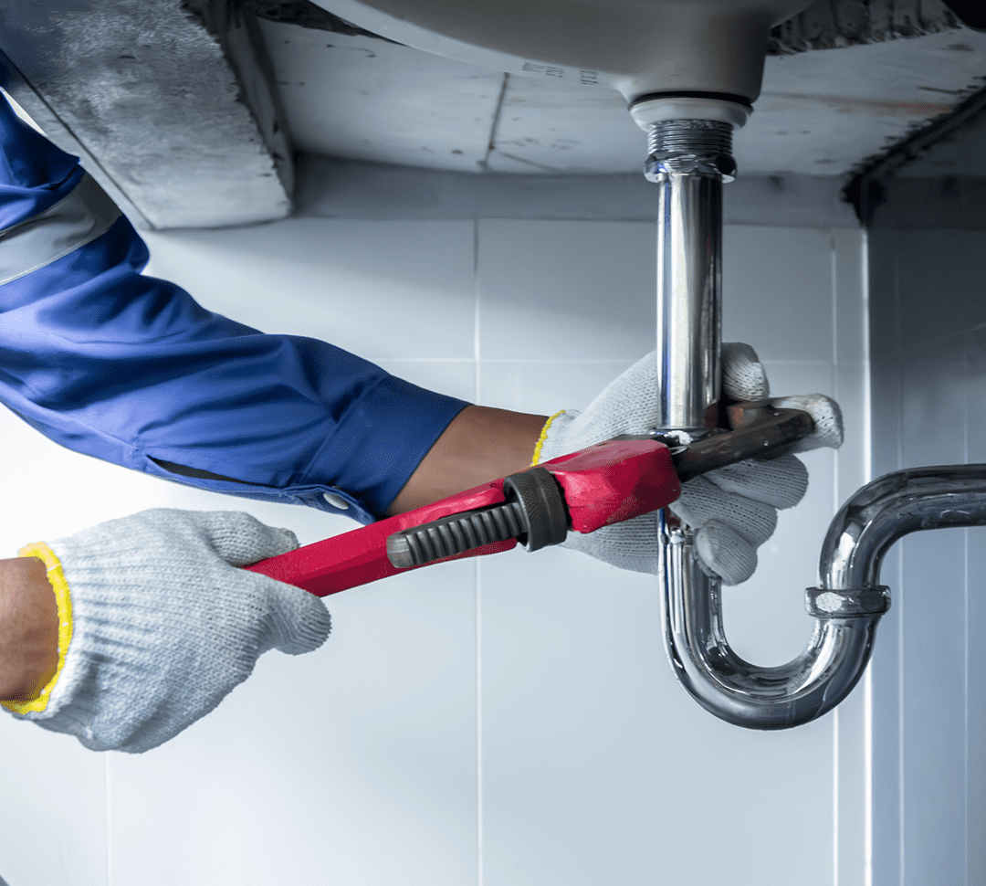 Hand with wrench repairing plumbing